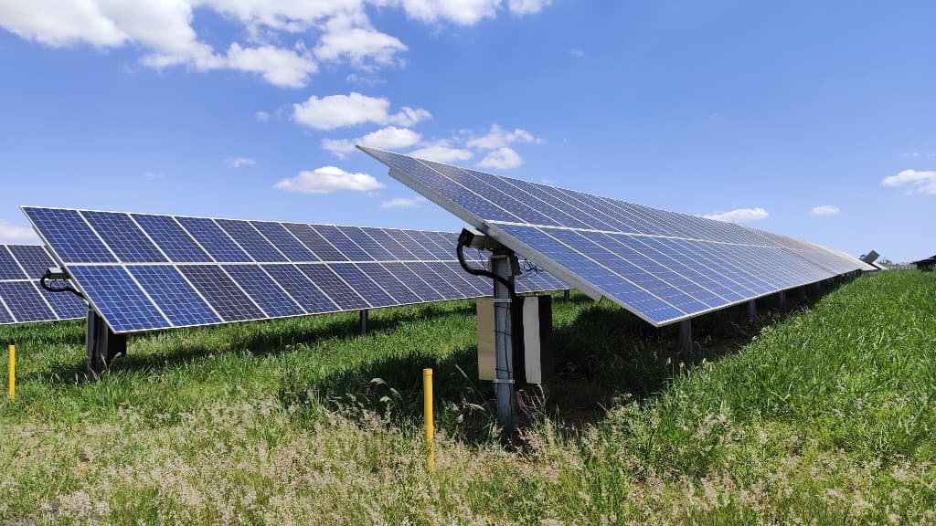 Rows of solar panels in a green field under a clear blue sky, representing a commissioned MSKVY 2.0 MoU route solar project